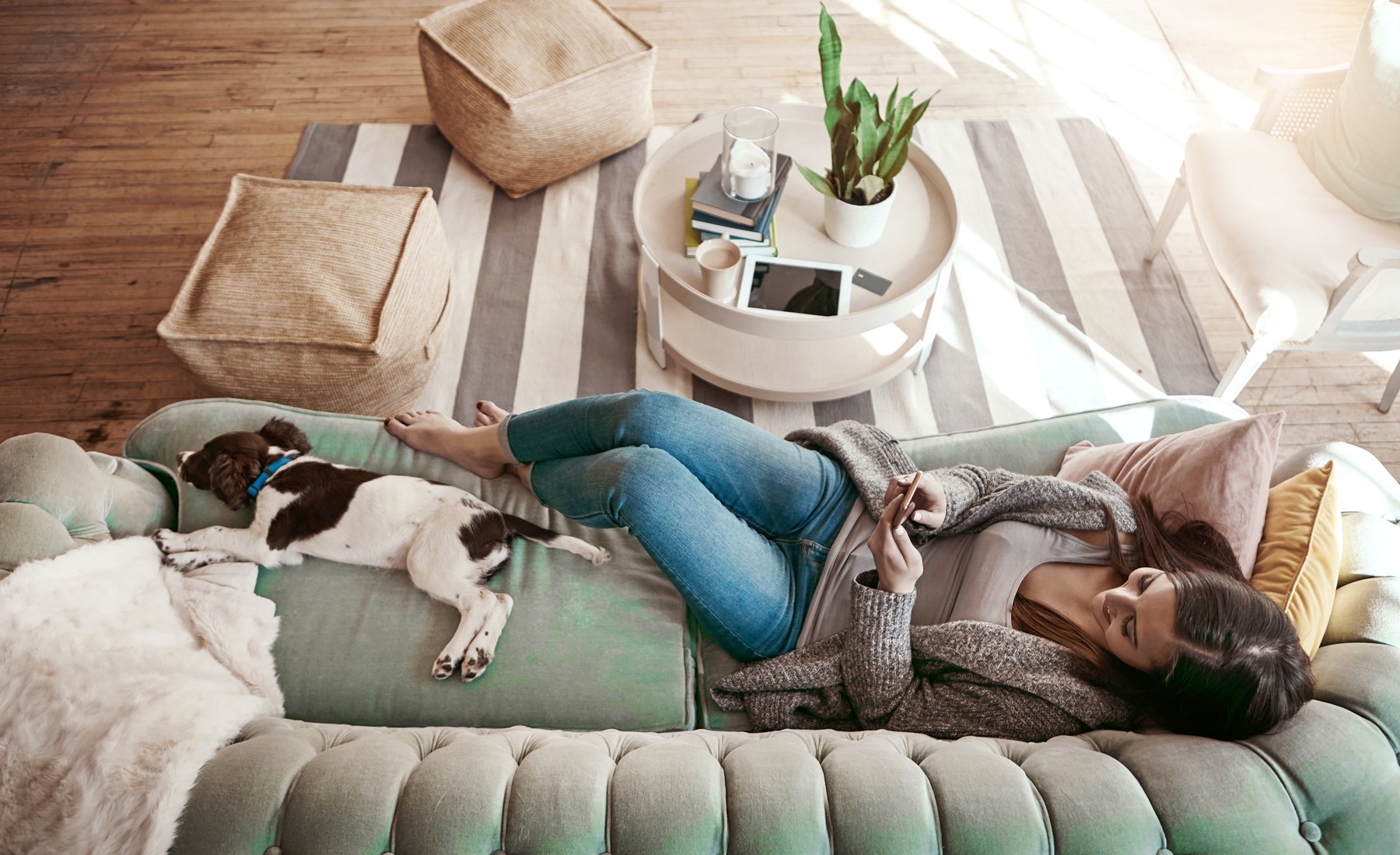 Kvinna och hund njuter i soffan av luftvärmepumpen